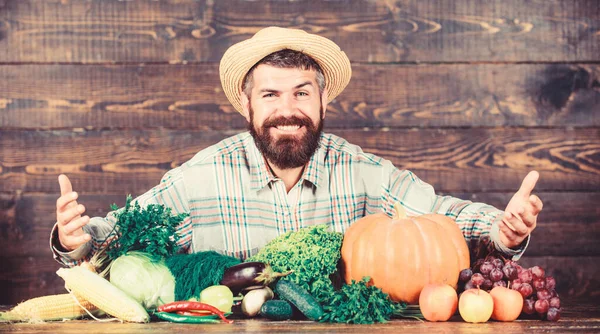 Vender verduras. Hombre agricultor barbudo con fondo de estilo rústico verduras. Comprar verduras granja local. Concepto de cultivos cultivados localmente. Mercado local. Hortalizas de cosecha propia. Festival de cosecha del mercado agrícola —  Fotos de Stock