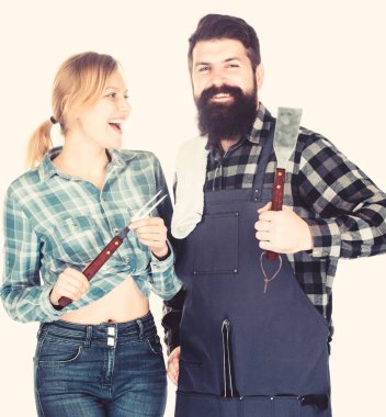 Piknik barbeküsü. yemek pişirme tarifi. Aile hafta sonu. Aşık çift mutfak eşyaları tutun. Adam sakallı hipster ve kız. Hazırlık ve mutfak. Et kavurma aletleri. Gülümseyen garson