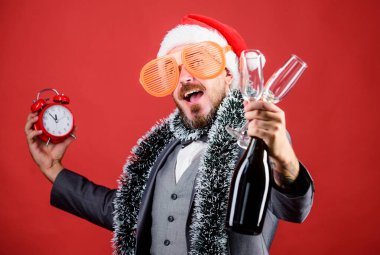 Süslü ve saatli bir iş adamı şapkası. Noel eğlenceli bir zamandır. Erkek işleri kadehten şampanya içer. Kış tatili zamanı. Sakallı adam Noel partisini kutluyor. Mutlu yıllar.