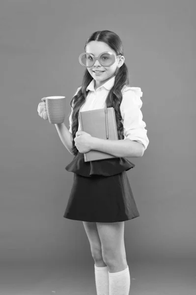 Small girl enjoying her school time. Happy little schoolgirl ready for lesson. Cute child with book. Study foreign language. Having tea break lunch time. Study literature. Pupil likes study