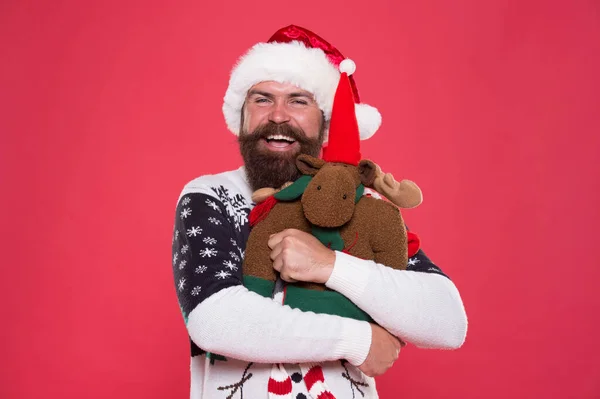 All I need is holiday. Happy santa hold toy gift pink background. Bearded man smile with festive holiday look. Christmas and new year party. Holiday celebration. Holiday gift delivery — Stock Photo, Image