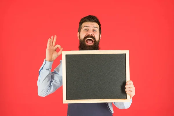 Os preços são ok. Menu de restaurante. anúncio de loja de café. Boas horas. Homem barbudo chalkboard, espaço de cópia. Empregado brutal na cozinha. homem maduro fundo vermelho. Barman hipster feliz. Entrega de alimentos — Fotografia de Stock