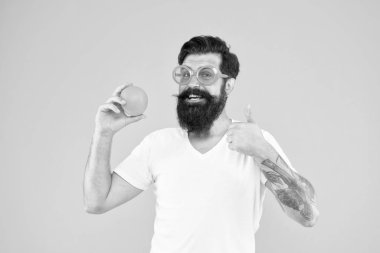 Sağlıklı yiyeceklere evet de. Sakallı adam başparmaklarını turuncuya kadar gösteriyor. Hipster turuncu arka plan üzerinde sağlığı için meyve gibi gesturing. Sağlıklı gıda deposu. Meyve yemek sağlığınızı artırabilir