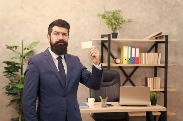 Bearded hipster top manager show card. Banking services for small business. Card design. Call now. Guy formal suit stand in office. Accountant or banker. Businessman hold blank card. Useful contacts