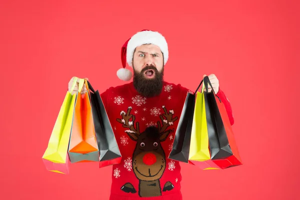 Έκπτωση. Χειμερινά ψώνια με προϋπολογισμό. Αναβάθμισε την γκαρνταρόμπα σου. Ένας μουσάτος χίπστερ φοράει χριστουγεννιάτικες τσάντες για ψώνια. Πώληση της εποχής. Αγοράστε δώρα για το νέο έτος. Ψώνια για δώρα. Ωραία αγορά. — Φωτογραφία Αρχείου