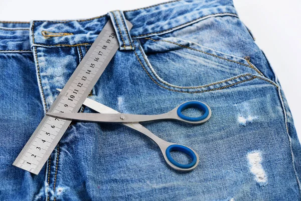 Поршневые инструменты на джинсовой ткани: металлические ножницы и линейка — стоковое фото