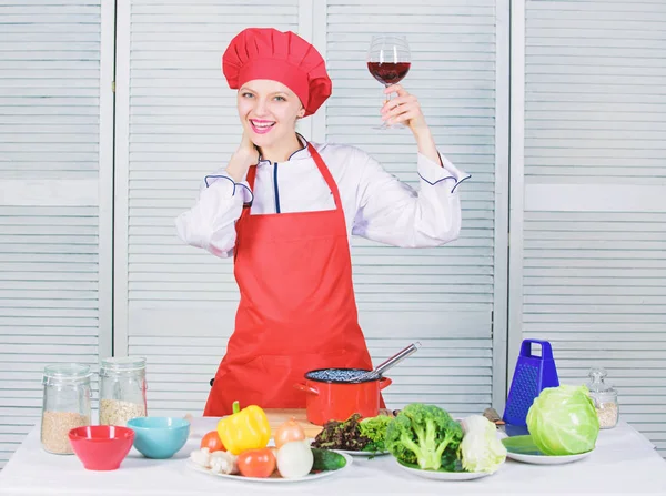 Köchin halten Glas Wein. welcher Wein zum Abendessen serviert wird. exquisites Dinner-Konzept. Weinverkostung. wie man Wein und Essen wie Experten zusammenbringt. Mädchen tragen Hut und Schürze genießen Aroma von Getränken — Stockfoto