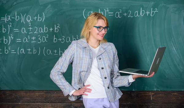 Koncept distančního vzdělávání. Žena učitel nosí brýle drží notebook surfování na internetu. Základní školní vzdělání. Učitel elegantní dáma s moderním notebookem surfování internetové desky pozadí — Stock fotografie