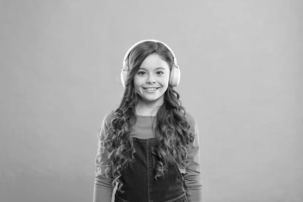 Laisse la musique t'emmener. Petit enfant mignon écoutant de la musique dans des écouteurs stéréo. Adorable fille appréciant la musique sur fond bleu. Éducation musicale pour les jeunes enfants — Photo