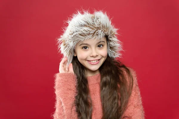 冬のファッションコンセプト。寒い天候のための暖かい帽子。完璧なアクセサリーだ。女の子は耳フラップ白の背景と帽子を着用します。柔らかい毛皮のアクセサリー。毛皮の衣服の手入れ。子供の長い髪柔らかい帽子は柔らかさを楽しむ — ストック写真