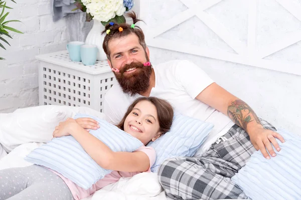 i love my daddy. happy morning together. funny pajama party. small girl with bearded father in bed. weekend at home. father and daughter having fun. family bonding time. dad and kid relax in bedroom