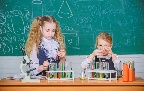 Mejorar sus habilidades de estudio. Grupo de estudio en laboratorio de química. Niños en edad escolar sosteniendo tubos de ensayo durante la sesión de estudio. Pequeñas colegialas realizando experimentos de estudio en química — Foto de Stock