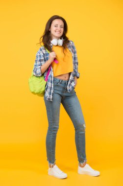 Gözlüklü yeni seksi. Mutlu öğrenci sarı arka planı. Üniversite öğrencisi sırt çantası taşıyor. Gündelik giysiler içinde güzel bir öğrenci gülümsemesi. Lise son sınıf öğrencisi. Kız okula geri döndü. Üniversitede. Yüksek öğrenim