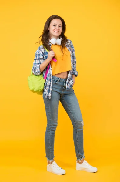 頭脳は新しいセクシーである。幸せな学生黄色の背景。大学生バックパックを運ぶ。カジュアルな服装でかなり学生の笑顔。高校3年生女の子は学校に戻る。大学だ高等教育 — ストック写真