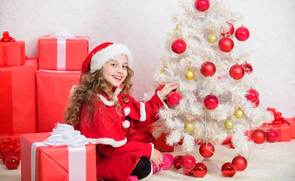 Vårdad semesteraktivitet. Barnet njuter av familjetraditionen. Julaftonskoncept. Följ med på julfirandet. Flicka leende förtjusande tomten sitter nära julgranen. Grabben dekorera julgran — Stockfoto