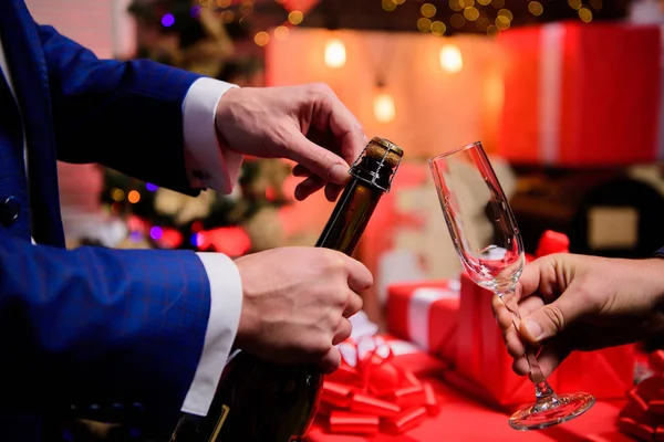 Último minuto antes do ano novo. Contagem regressiva de ano novo. Beba champanhe ou vinho espumante. Celebre o Ano Novo com o champanhe. Mãos abrindo garrafa de champanhe e segure vidro decorações de Natal fundo — Fotografia de Stock