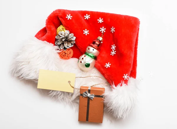 保持家庭传统。圣诞老人红帽白色背景顶视图。桑塔送的圣诞礼物。寒假的特点。新年和圣诞节庆祝活动。圣诞礼盒圣诞礼帽 — 图库照片