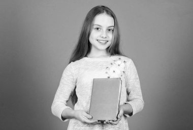 Bir kitabı kapağına bakarak söyleyemezsin. Sevimli küçük kız kitabı tutuyor. Elinde kitap olan sevimli küçük bir çocuk. İngilizce kitap okumayı seviyor, kopyalamayı.