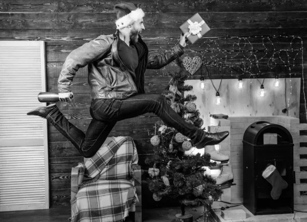 Man santa hat hurry to deliver gift on time. Christmas is coming. Spread happiness and joy. Bearded guy in motion jump. Delivery christmas present. Still have time. Delivery service. Gifts delivery