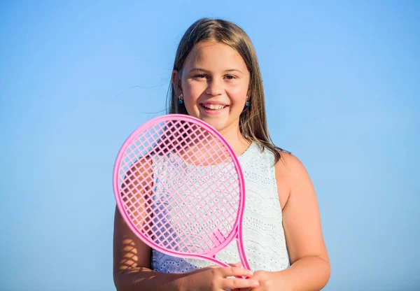 Sportovní kluk. Malá holka s růžovou tenisovou raketou. Letní volný čas. Sportovní hra. Hravé, veselé dítě. Šťastné dětství. Naprosto. Emocionální dítě. Aktivní život. Dítě hrát tenis modrá obloha pozadí — Stock fotografie