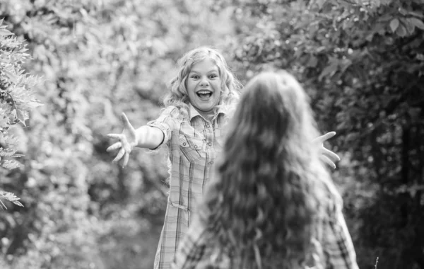 long-awaited meeting. happy little girls with long healthy hair. hair health and care. hairdresser fashion and beauty. long curly hair. girls friends meet in forest. summer vacation. childrens day