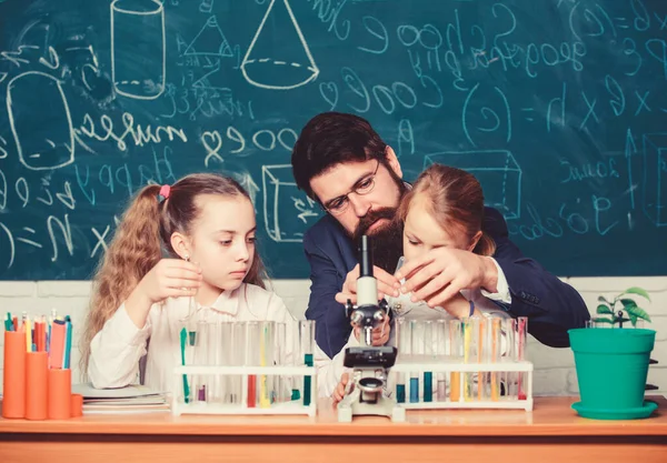 Explaining biology to children. How to interest children study. Fascinating biology lesson. Man bearded teacher work with microscope and test tubes in biology classroom. School teacher of biology