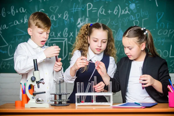 A lányok és a fiúk folyadékkal kísérleteznek az iskolában. Iskolai kémia óra. Kísérleti csövek anyagokkal. Formális oktatás. Iskolai laboratórium. A csoportos tanuló vegyi folyadékot tanul. — Stock Fotó