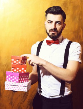 Sakallı adam elinde ciddi yüzlü hediye kutuları tutuyor.