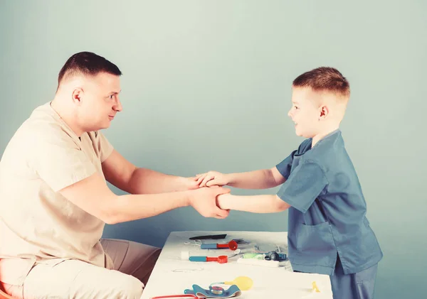 El pediatra cuidadoso comprueba la salud del niño. Examen médico. Servicio médico. Hombre doctor sentarse mesa herramientas médicas examinando niño pequeño paciente. Salud. Concepto de pediatra. Cuidado de niños —  Fotos de Stock