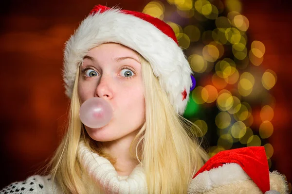 Jen mě to baví. Děvče Santa Claus dělá velkou bublinu s žvýkačkou. Vtipná tvář zblízka. Rozkošná žena fouká bublinu. Vánoční holka udělala bublinkovou pěnu. Šílená grimasa. Bubliny s žvýkačkou — Stock fotografie