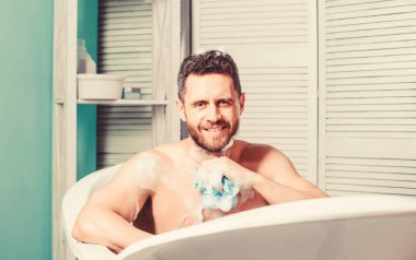Sıcak veya sıcak banyo ile kendinizi tedavi lüks yüksekliği gibi hissedebilirsiniz. Şımartma ve güzellik rutini. Adam yakışıklı kaslı adam banyoda rahatlatıcı. Spa sağlıklı yaşam konsepti. Sabun suds ile banyo alma