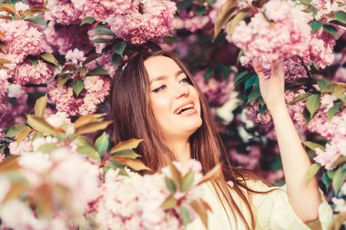 Kiraz çiçeği çiçeğindeki kız. Sakura ağacı açıyor. Kozmetik konsepti. Muhteşem çiçek ve kadın güzelliği. Bahar çiçeğindeki kadın. Yumuşak ve yumuşak. Cilt için doğal kozmetik. Çiçek cenneti