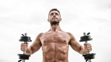 Dambılla egzersiz yapan kaslı bir adam. Aptal egzersiz salonu. Büyüklüğün bedeli sorumluluktur. Güçlü gövdeli bir sporcu. Spor aletleri. Fitness ve vücut geliştirme sporu. Jimnastik konsepti