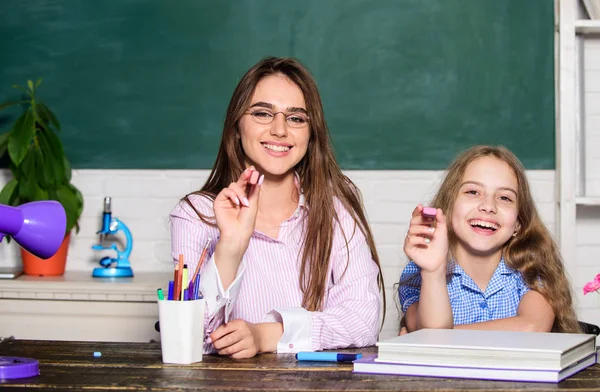 Hulp met huiswerk. Huiswerk project. Zuster helpt met leren. Leraar vriendelijke dame met leerling. Huiswerk maken met mama. Kleine meid en vrouw zitten aan het bureau. Schoolonderwijs. Samen studeren — Stockfoto