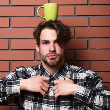 Elinde bardak tutan yakışıklı adam.