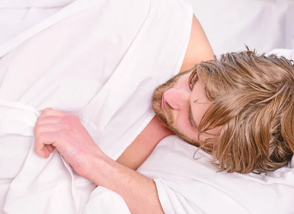Ο εύθυμος νεαρός ξυπνάει μετά τον ύπνο το πρωί. Γυμνά πόδια ενός άντρα που κρυφοκοιτάζει έξω από τον όρμο. Κορυφαία θέα του σέξι μυών νεαρό άντρα που κοιμάται στο κρεβάτι. — Φωτογραφία Αρχείου