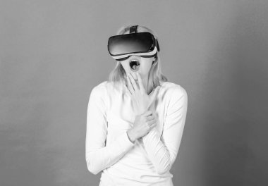 Sanal gerçeklik giyen kadın mavi arka planda gözlükler. Kadın zevk cyber eğlence deneyimi vr içinde. Genç kadın Vr deneyimi sırasında hava dokunmadan hayran. Teknik ağ.