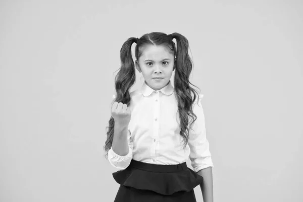 Tan loco. Pequeño niño disgustado con la educación. Niña de la escuela haciendo un gesto de su puño con ira sobre fondo amarillo. No me gusta la escolaridad obligatoria. Tener una escuela privada. Años escolares — Foto de Stock