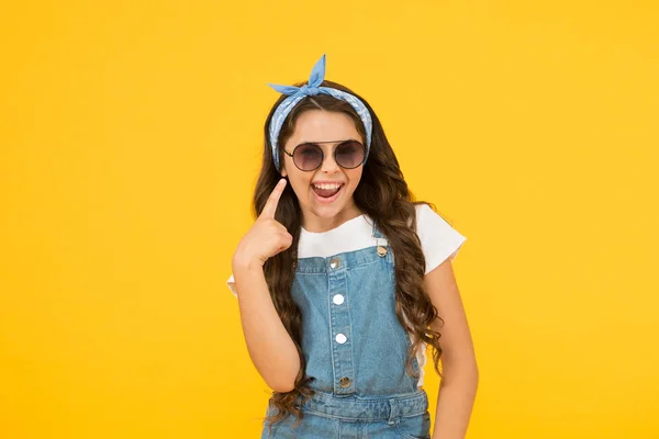 Mira esto. Modo de vacaciones activado. Pequeña fashionista. Boutique de ropa para niños. Chica retro. Moda de verano. alegre niña de fondo amarillo. pelo largo retro niño. gafas de sol vintage para niños pequeños — Foto de Stock