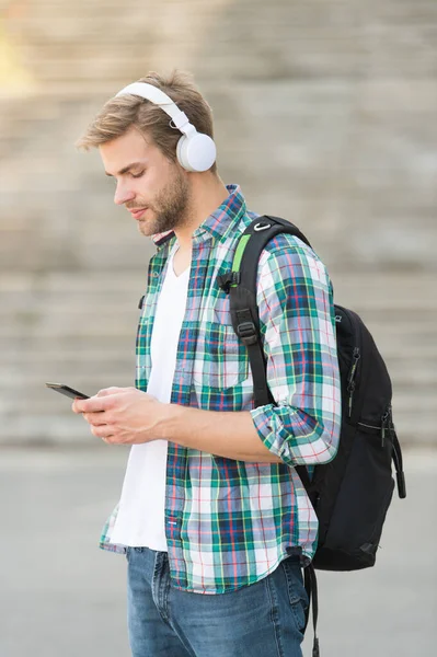 trendy man typing message. College student earphones smartphone. Online education. Audio book concept. Educational technology. student e learning. school life. Listen music. Modern and digital youth