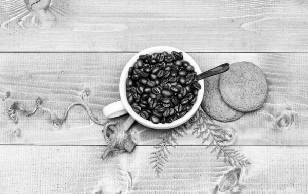 Fresh roasted coffee beans. Cup full coffee brown roasted bean blue wooden background. Caffeine concept. Cafe drinks menu. Arabica robusta coffee variety. Beverage for inspiration and energy charge