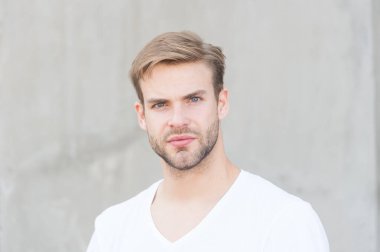 Kendini sev. Erkek çekiciliğinin portresi. Genç, seksi, gri arka plan. Tıraşsız maço adam. Yaz erkek modası. Öğrenci traşsız, stil sahibi saç stili. Sakallı adam, sıradan bir tarz.