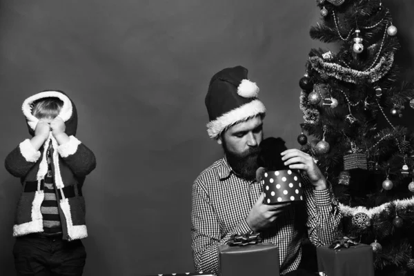 Man en jongen in Santa hat spelen verstoppertje — Stockfoto