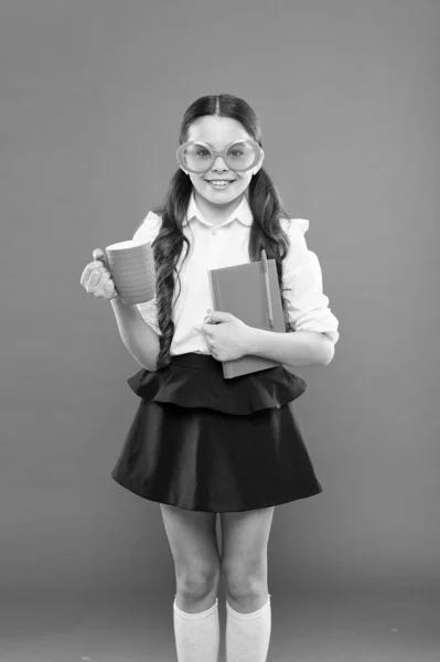 Hora do almoço. menina da escola feliz em uniforme e óculos de festa. criança pequena com caderno. leitura de educação. escrevendo na pasta de trabalho. literatura infantil. obter informações do livro. O miúdo bebe chá. o meu ensaio — Fotografia de Stock