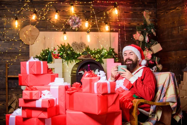 Es la temporada para ser Jolly. hombre barbudo con caja presente. regalos de Navidad. ventas de Navidad. Feliz navidad. Feliz año nuevo. traje de santa rojo. hombre feliz beber té. leche para santa — Foto de Stock