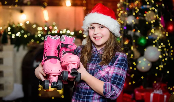 Feliz Navidad y Feliz Año Nuevo. Niño elfo con patines. Regalo navideño. Niña con sombrero rojo. Regalo de vacaciones. Caja de regalo. Santa Claus niña. Presente de compras. Regalo para ti — Foto de Stock