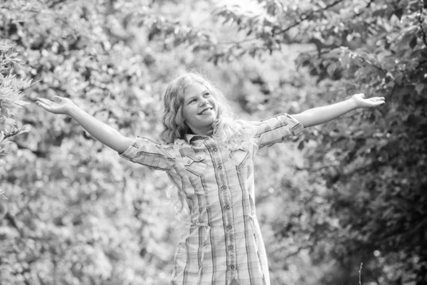 Criança sorridente menina bonito longo cabelo encaracolado natureza fundo. Caminhe ar fresco. Bom humor. Férias. Rapariga do rancho. Cuidados naturais. Menina adorável ao ar livre. Conceito de cosméticos. Infância feliz — Fotografia de Stock