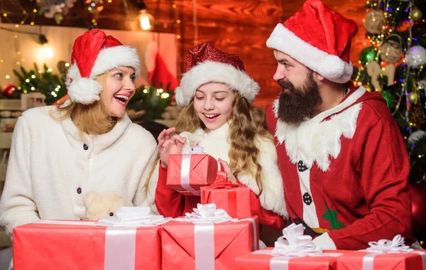素晴らしいプレゼントだ。サンタ・ハットの小さな子供と両親。メリー・クリスマス。父と母は娘を愛する。幸せな家族は新年を祝う。クリスマスプレゼント箱。プレゼントを開けなさい。冬休みだ。ショッピング販売 — ストック写真