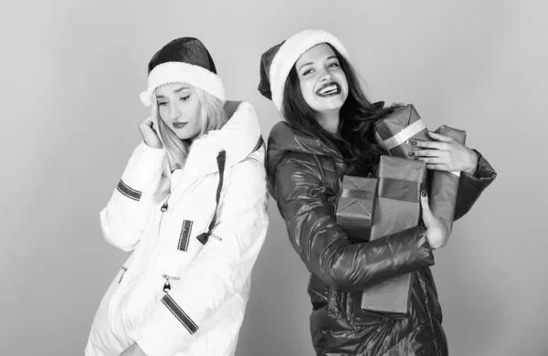 Только посмотрите на это. Рождественская мода. веселье и подарки. дружба и сестринство. С Новым годом. xmas present box. зимние каникулы. семейный отдых. женщин в пуховике. Девушки Санта-Клаус шляпа — стоковое фото