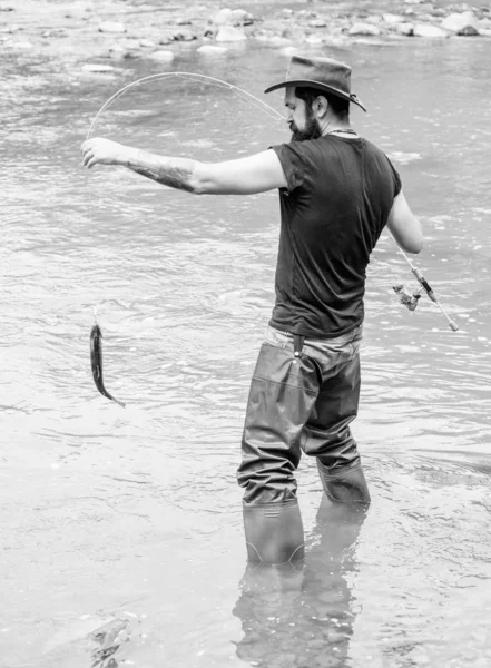Balıkçılık erkeksi hobi. Acımasız adam nehir suyunda dikilir lastik çizmeler giyer. Fisher hafta sonu aktivitesi. Balıkçı ekipmanları ile Fisher. Kancadaki balıklar. Vahşi doğada eğlence. Balıkçılık Fun yakalamak — Stok fotoğraf